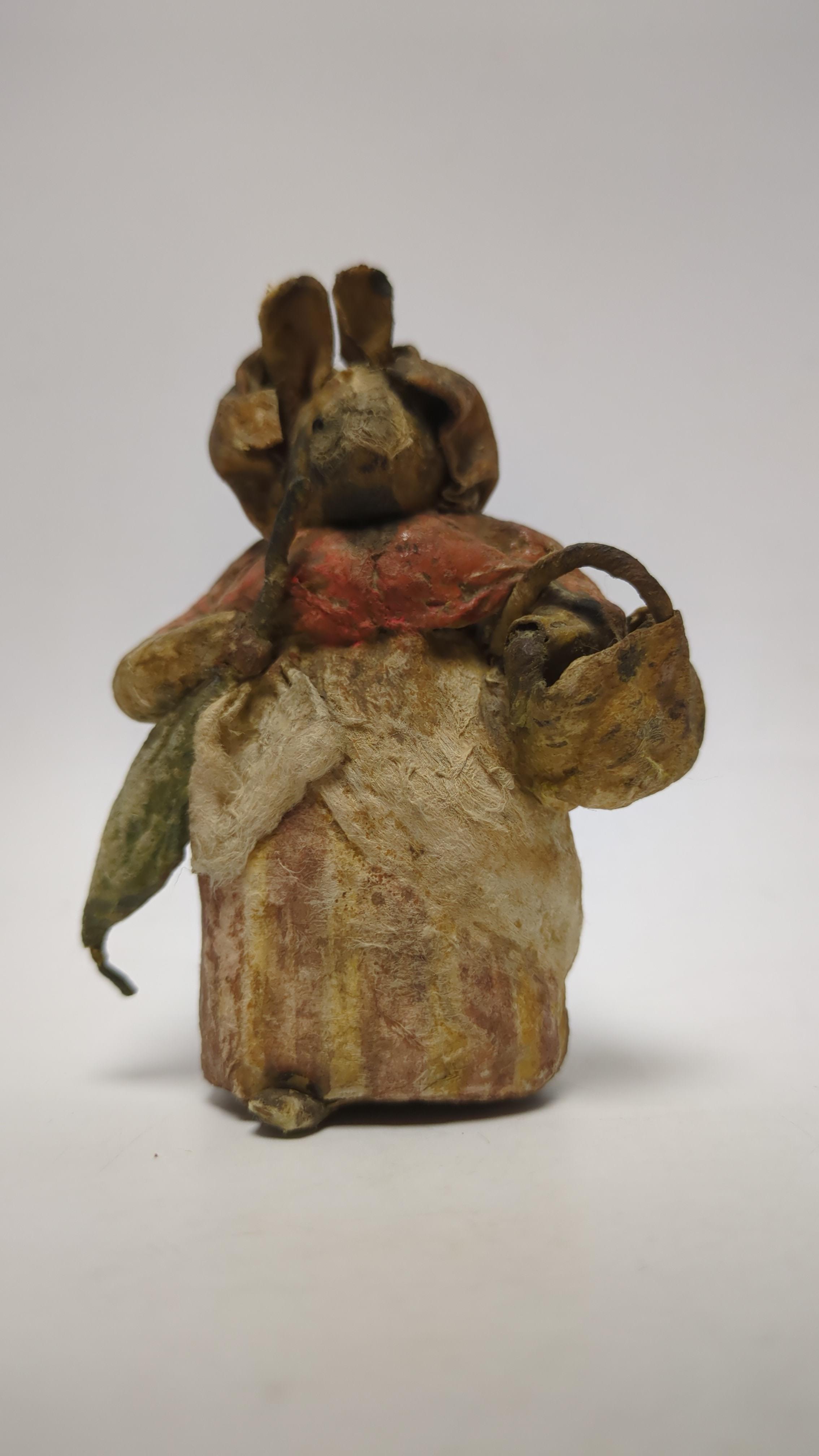 An F. Warne papier-mâché Beatrix Potter figure of Mrs. Rabbit with basket and umbrella, red and white F. Warne & Co. paper label to the base, dating it to pre-1917, 8.5cm high